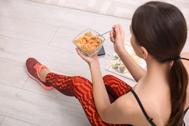 Photo of Young woman in fitness clothes having healthy breakfast at home