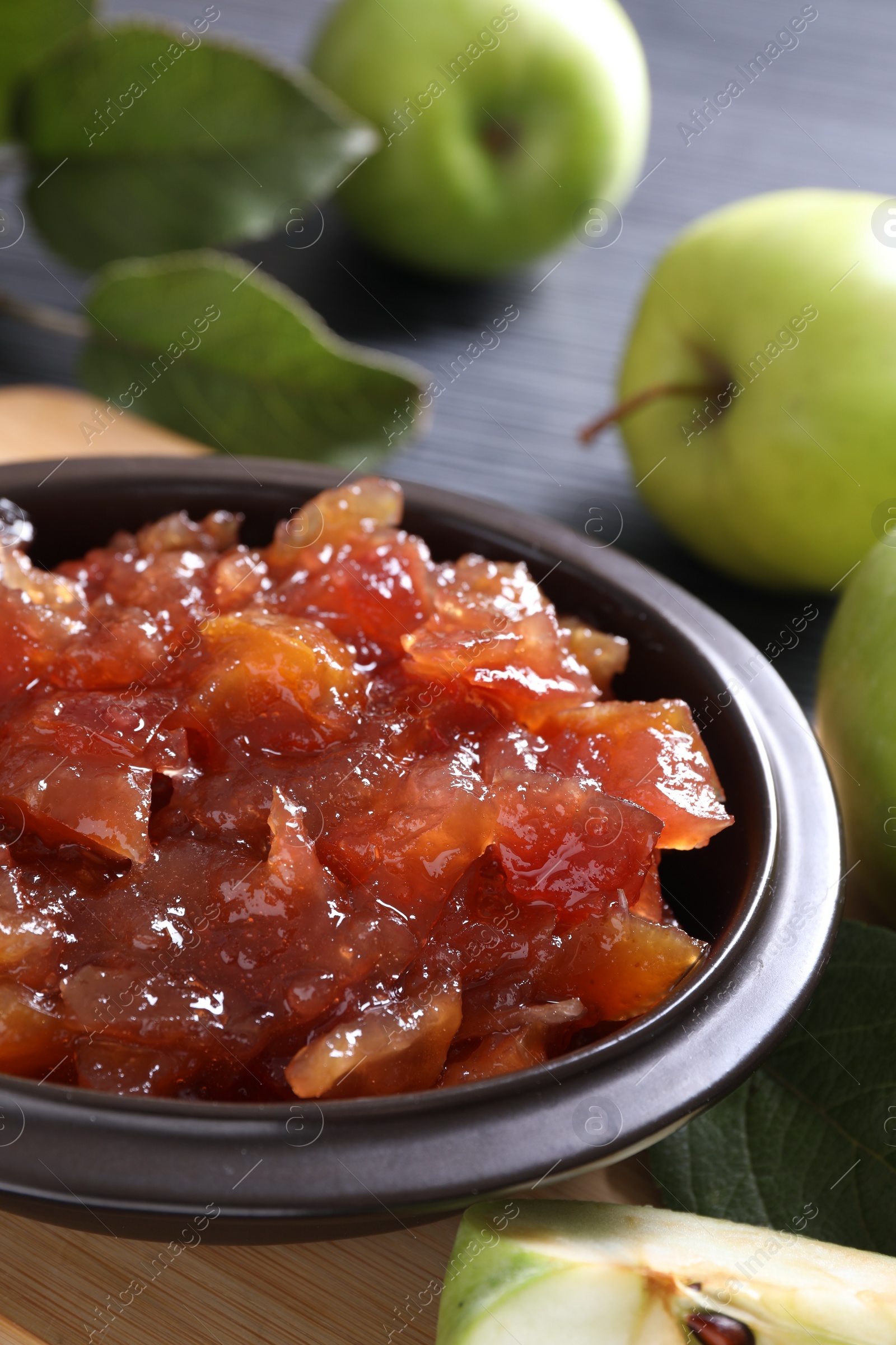 Photo of Bowl of delicious apple jam and fresh fruits on table, closeup. Space for text