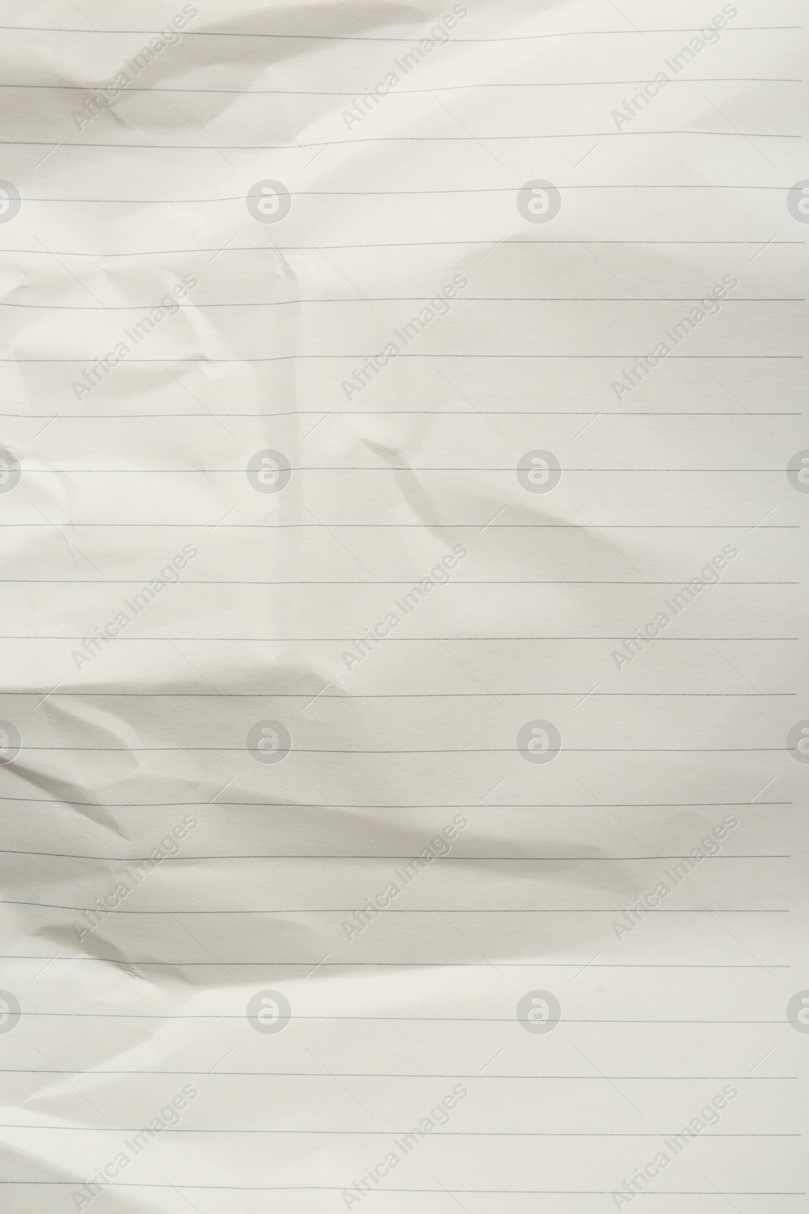 Photo of Crumpled lined notebook sheet as background, top view