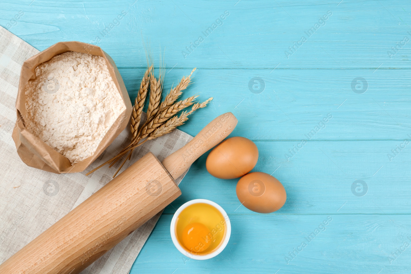 Photo of Flat lay composition with raw eggs on light blue wooden table. Baking pie