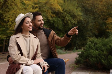 Photo of Romantic young couple spending time together in autumn park, space for text