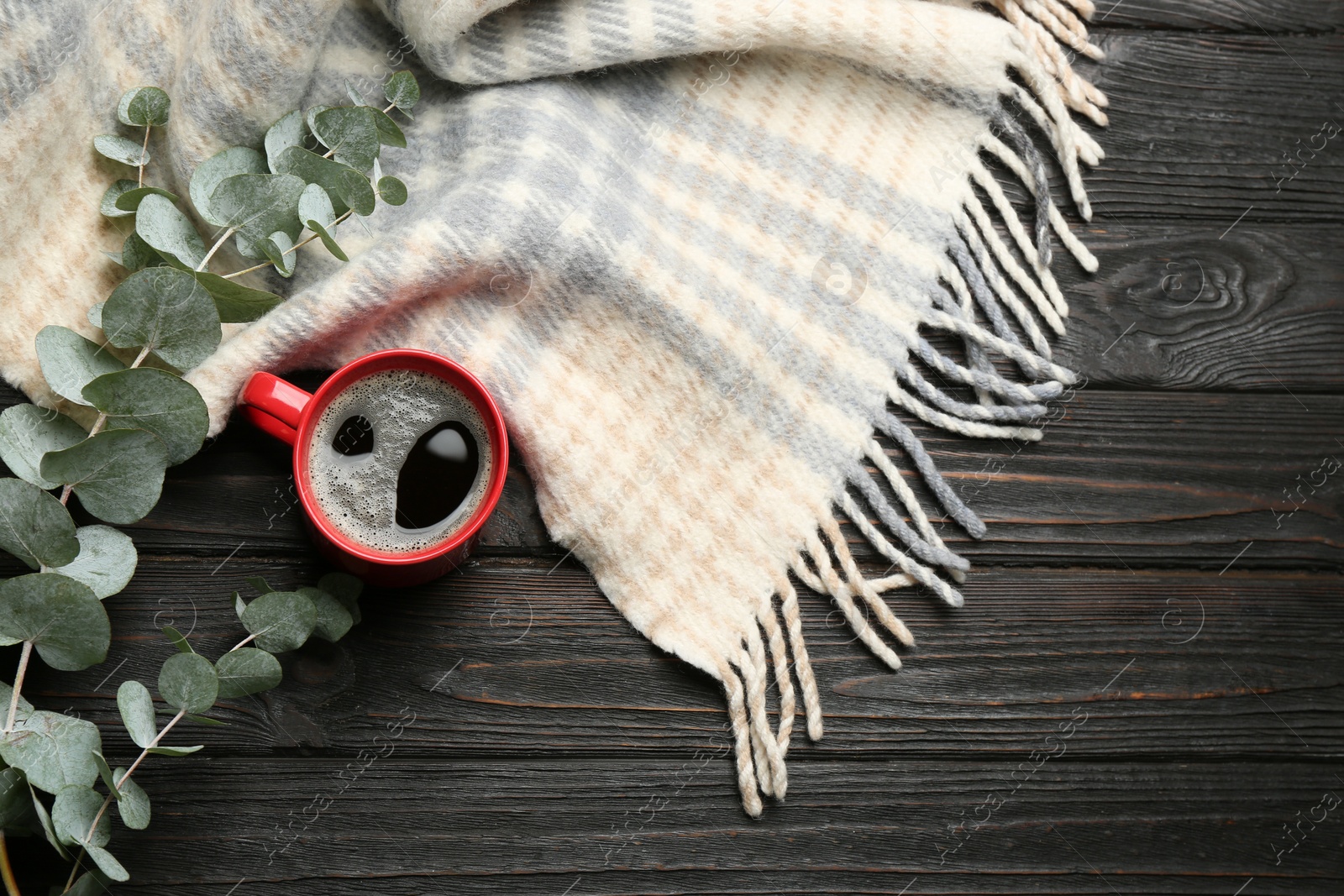 Photo of Flat lay composition with hot drink and warm plaid on black wooden table