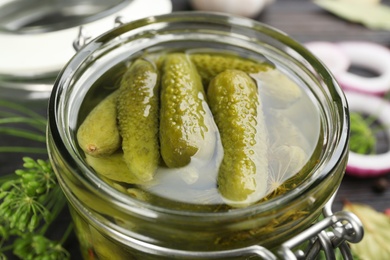 Photo of Glass jar of tasty pickled cucumbers, closeup