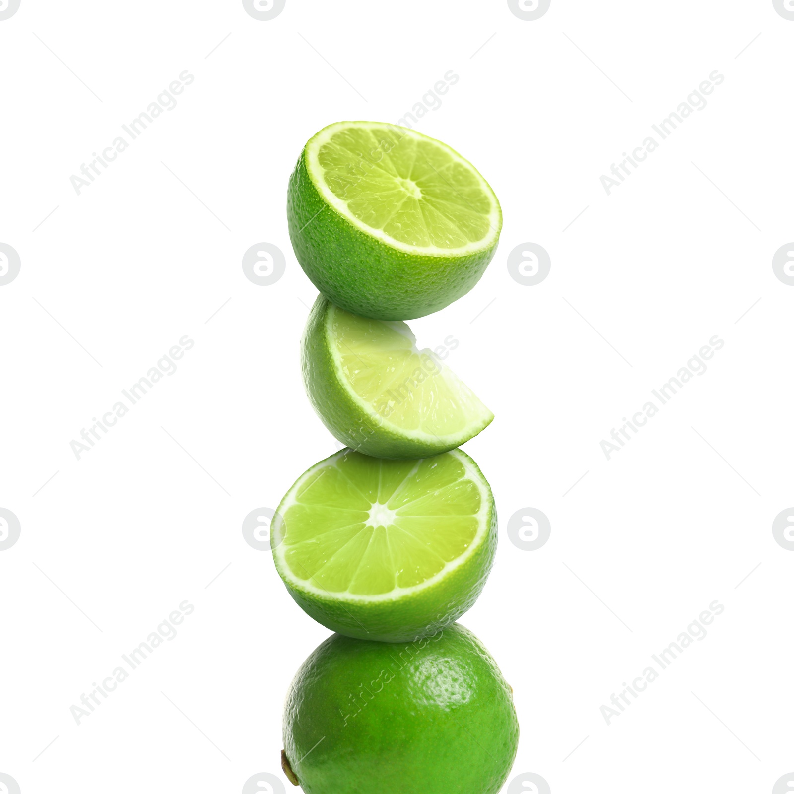 Image of Stacked cut and whole limes on white background