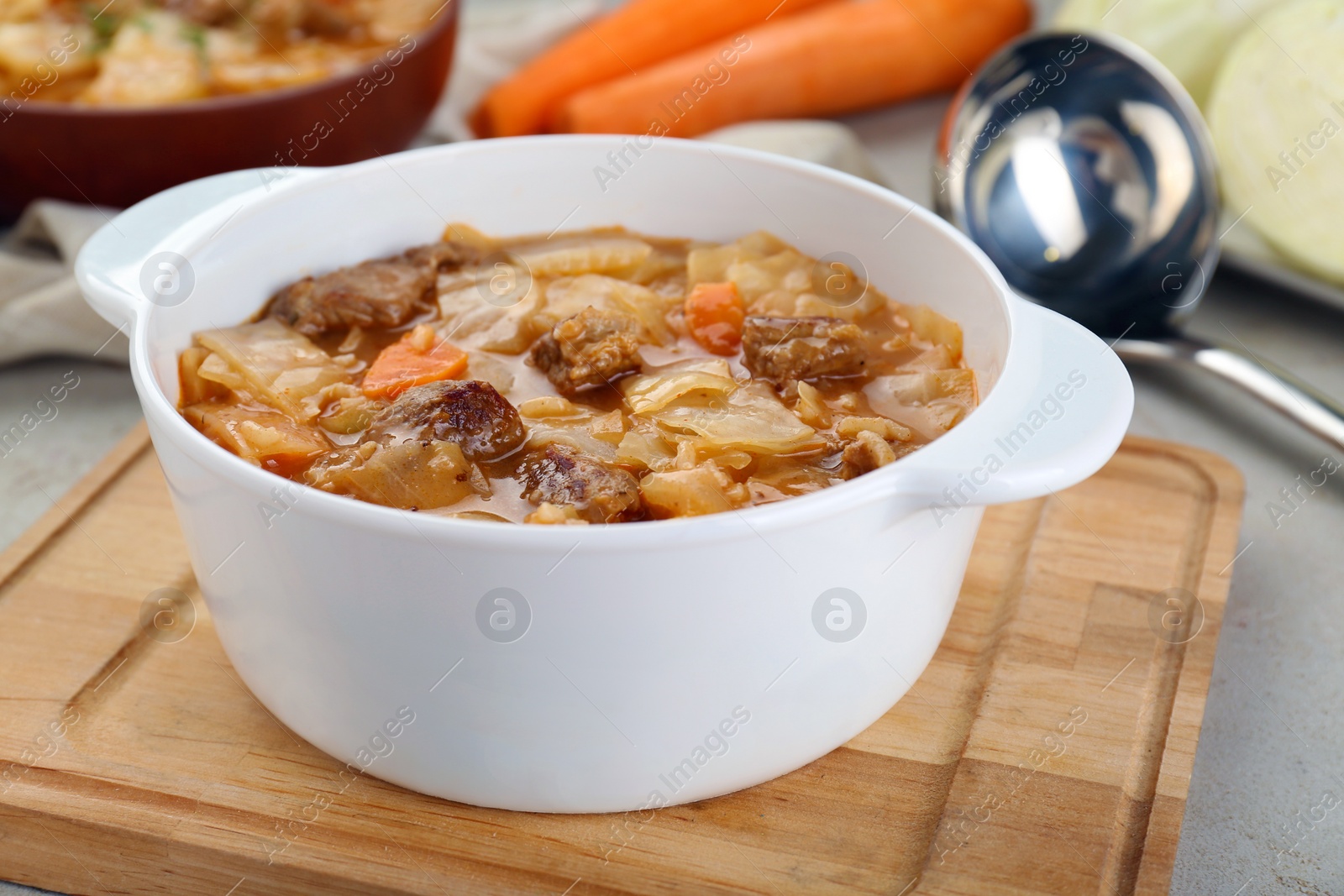 Photo of Tasty cabbage soup with meat and carrot on table, closeup