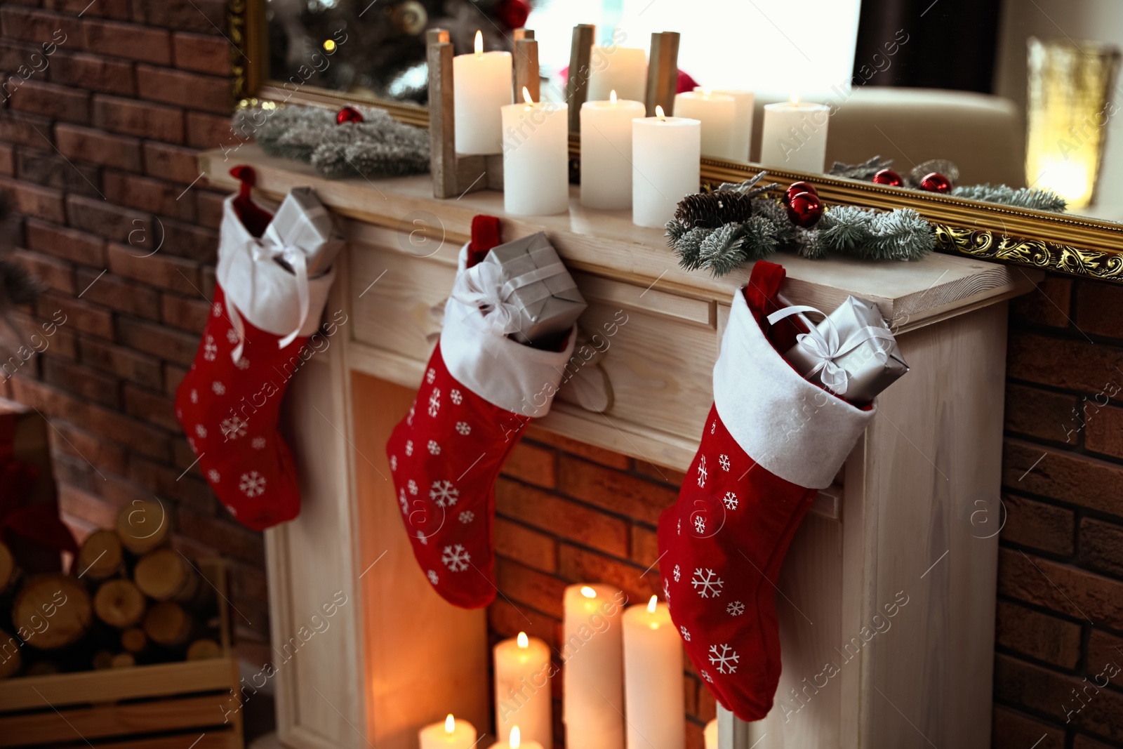 Photo of Decorative fireplace with Christmas stocking and gifts in stylish room interior