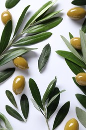 Photo of Fresh green olives and leaves on white background, flat lay