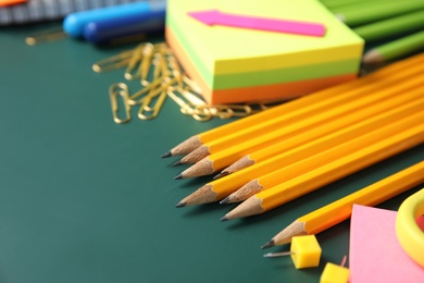 Photo of Different colorful stationery on chalkboard surface. Back to school