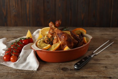 Photo of Baked chicken with orange slices on wooden table