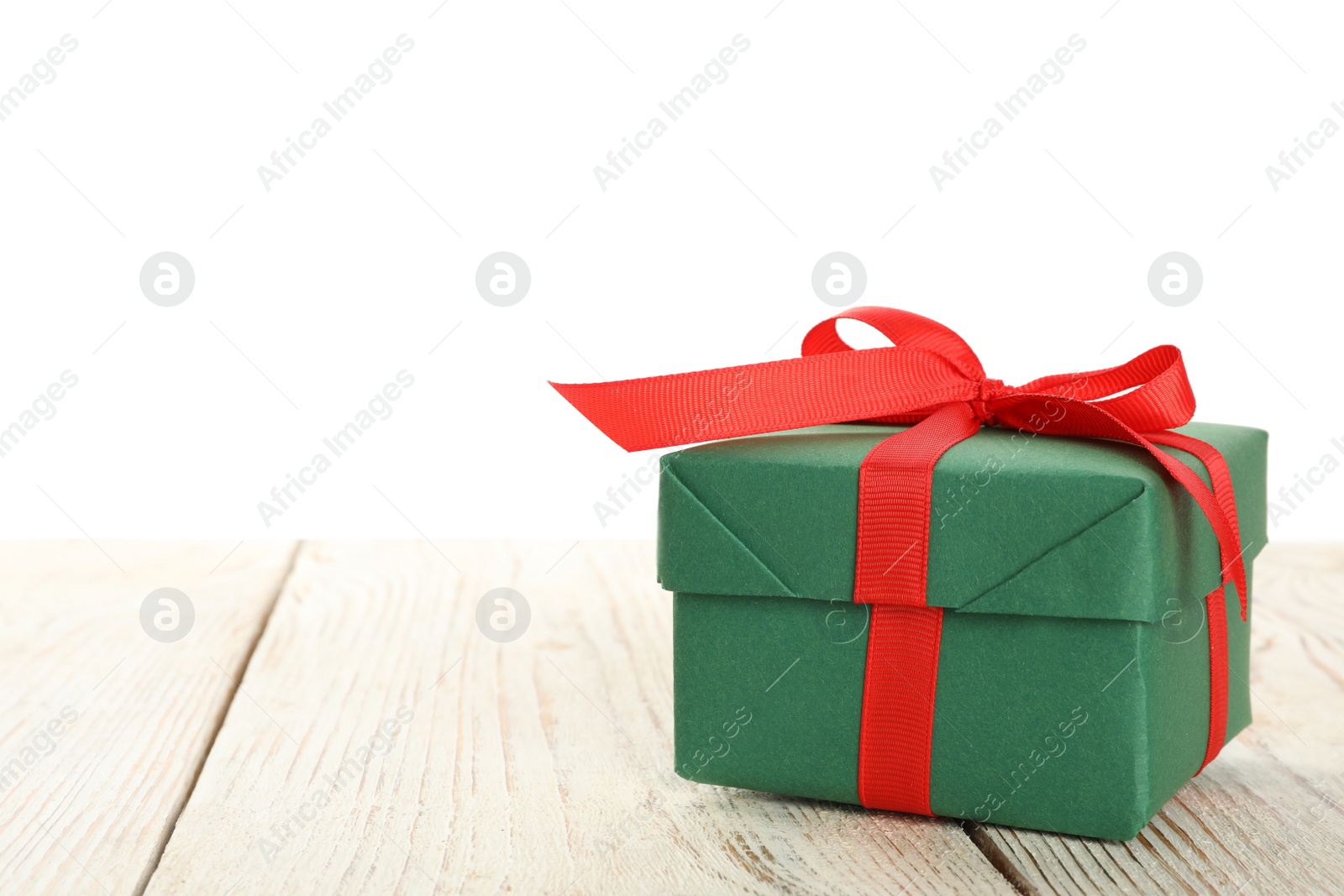 Photo of Christmas gift on wooden table against white background. Space for text