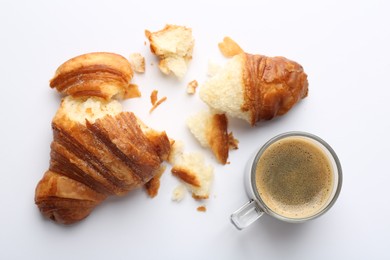 Delicious fresh croissant and cup of coffee on white background, flat lay