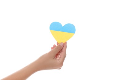 Woman holding paper heart in colors of Ukrainian flag on white background, closeup