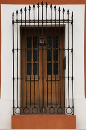 Photo of Entrance of residential house with wooden door and steel grilles