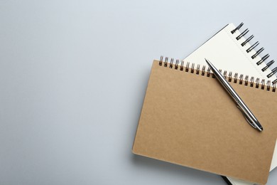 Photo of Notebooks on light grey background, top view. Space for text