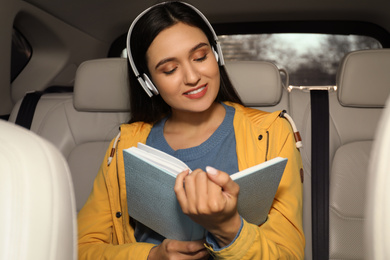 Photo of Young woman listening to audiobook in car