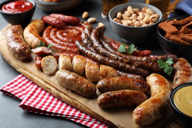 Photo of Set of different tasty snacks on dark grey table, closeup view