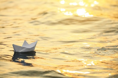 Photo of Paper boat floating on water outdoors. Space for text