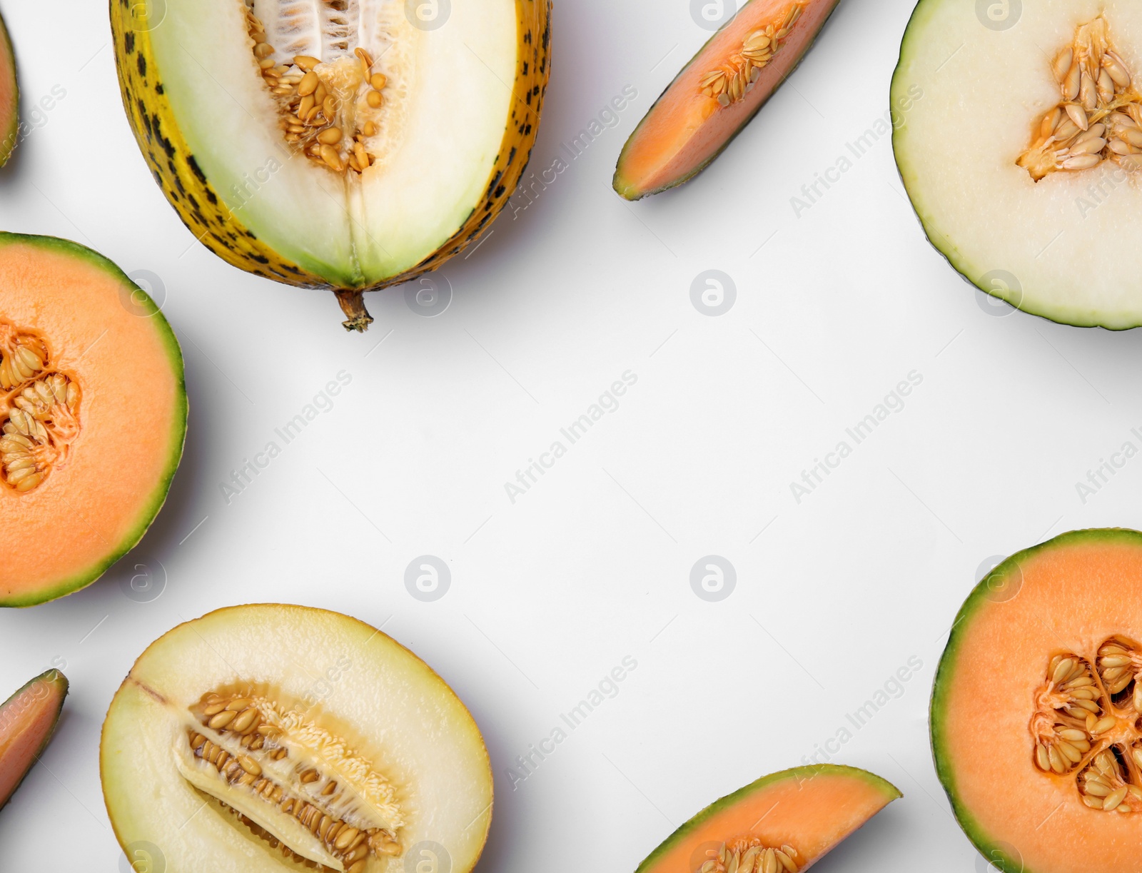 Photo of Cut different types of melons on white background, flat lay. Space for text