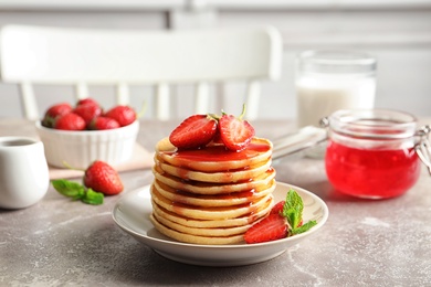 Photo of Plate with pancakes and berries on table