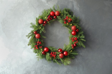 Photo of Beautiful Christmas wreath with festive decor on grey wall