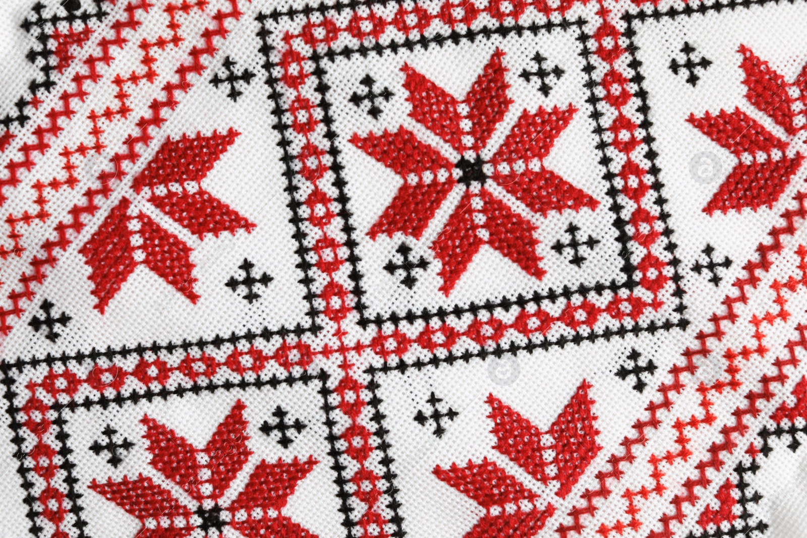 Photo of Traditional Ukrainian embroidery on white canvas as background, closeup. National handicraft