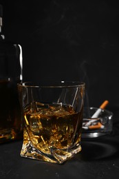 Photo of Alcohol addiction. Whiskey in glass on dark textured table, closeup