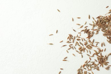 Aromatic caraway (Persian cumin) seeds on white table, top view. Space for text