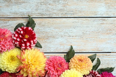Photo of Beautiful dahlia flowers on wooden background, flat lay. Space for text