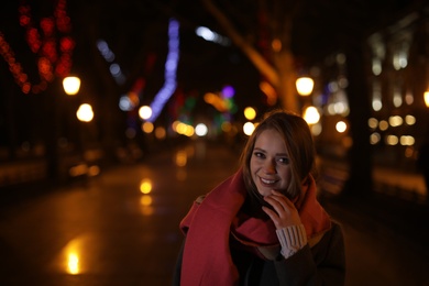 Beautiful young woman spending time in city at night