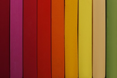 Photo of Set of colorful pastels as background, closeup. Drawing materials