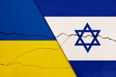 Flags of Ukraine and Israel on broken wall. International diplomatic relationships