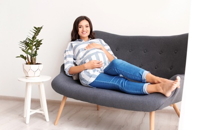 Photo of Beautiful pregnant woman on sofa at home