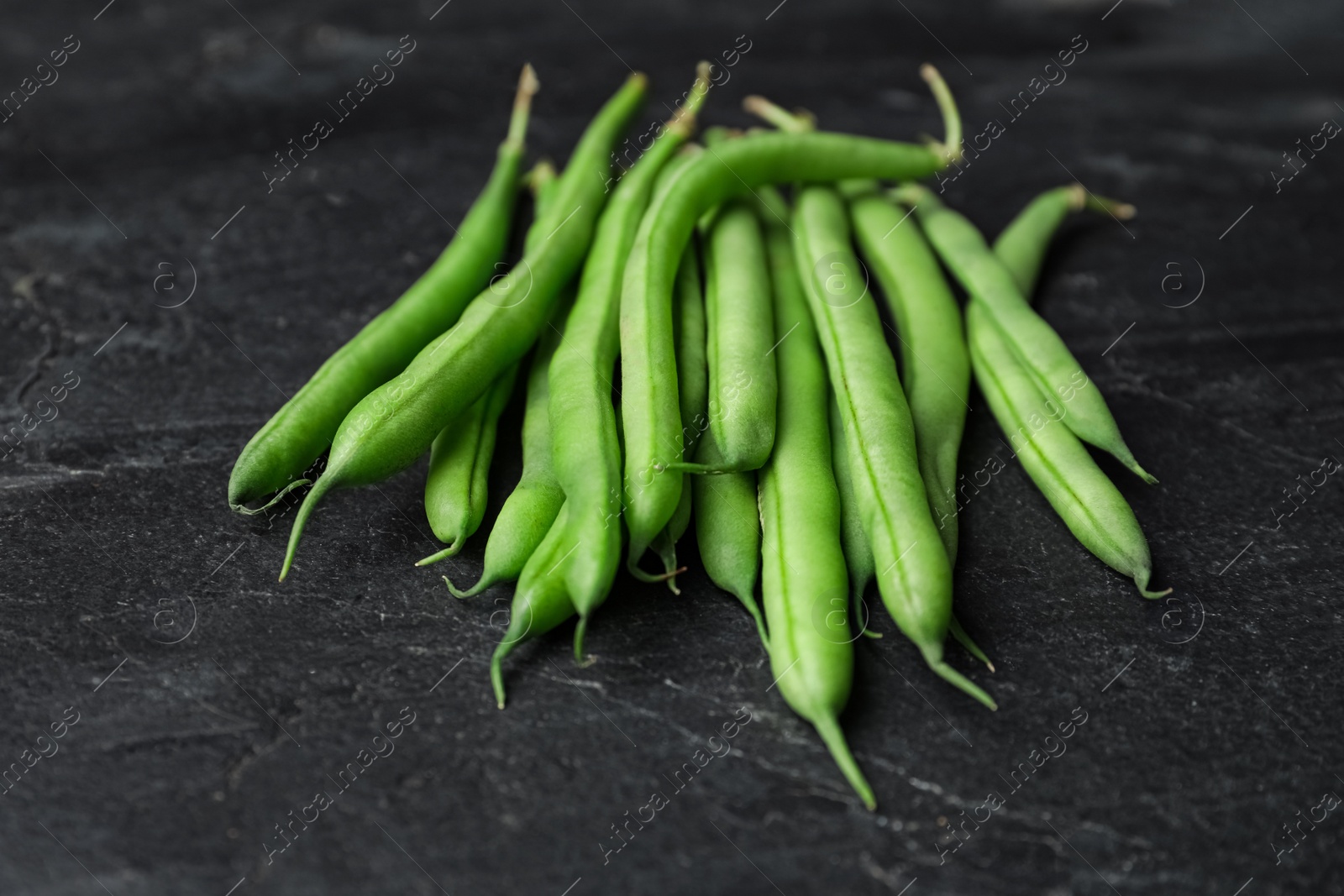 Photo of Fresh green beans on black table, closeup