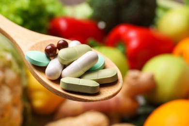 Photo of Different dietary supplements in wooden spoon near products, closeup. Space for text