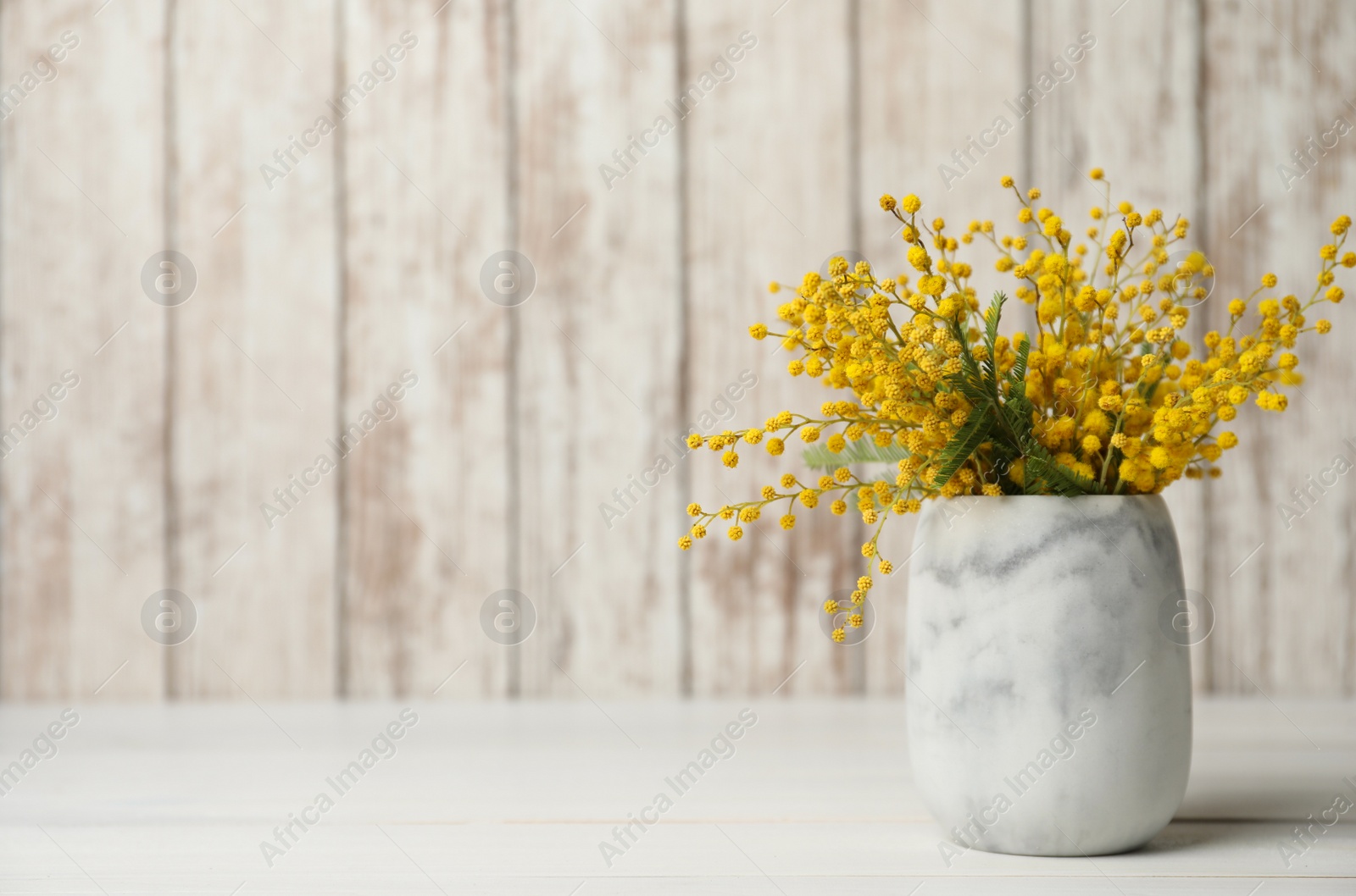 Photo of Bouquet of beautiful mimosa flowers on white wooden table. Space for text