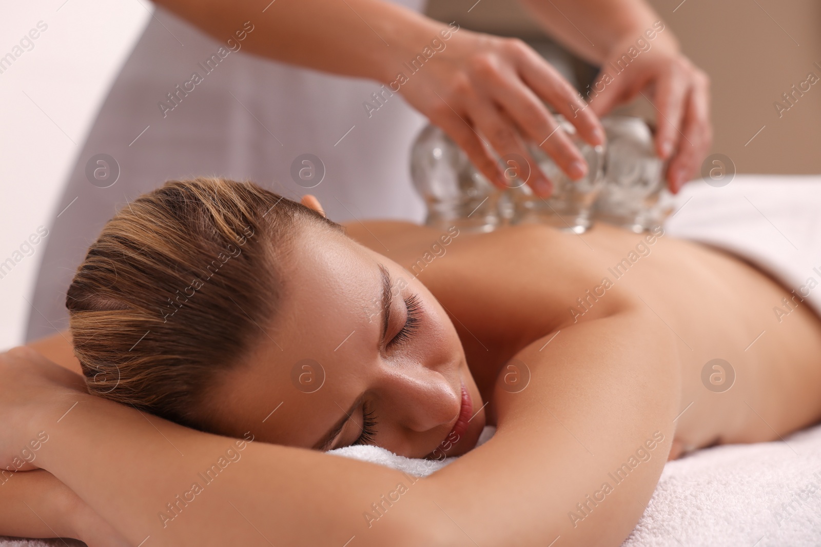 Photo of Therapist giving cupping treatment to patient indoors