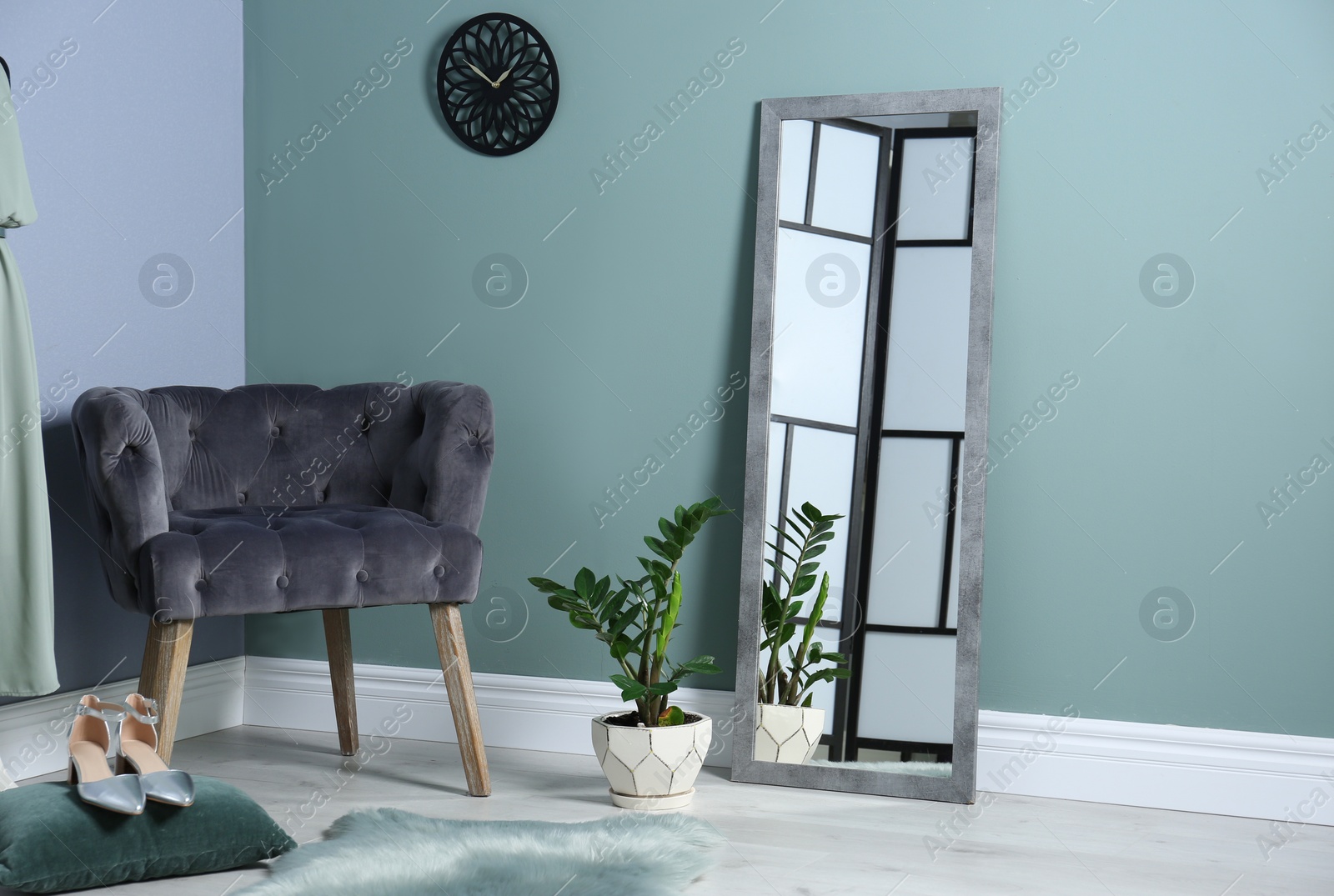 Photo of Elegant room interior with large mirror and comfortable armchair
