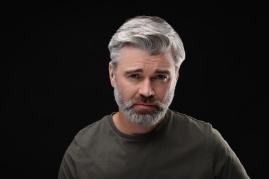 Photo of Personality concept. Portrait of emotional man on black background