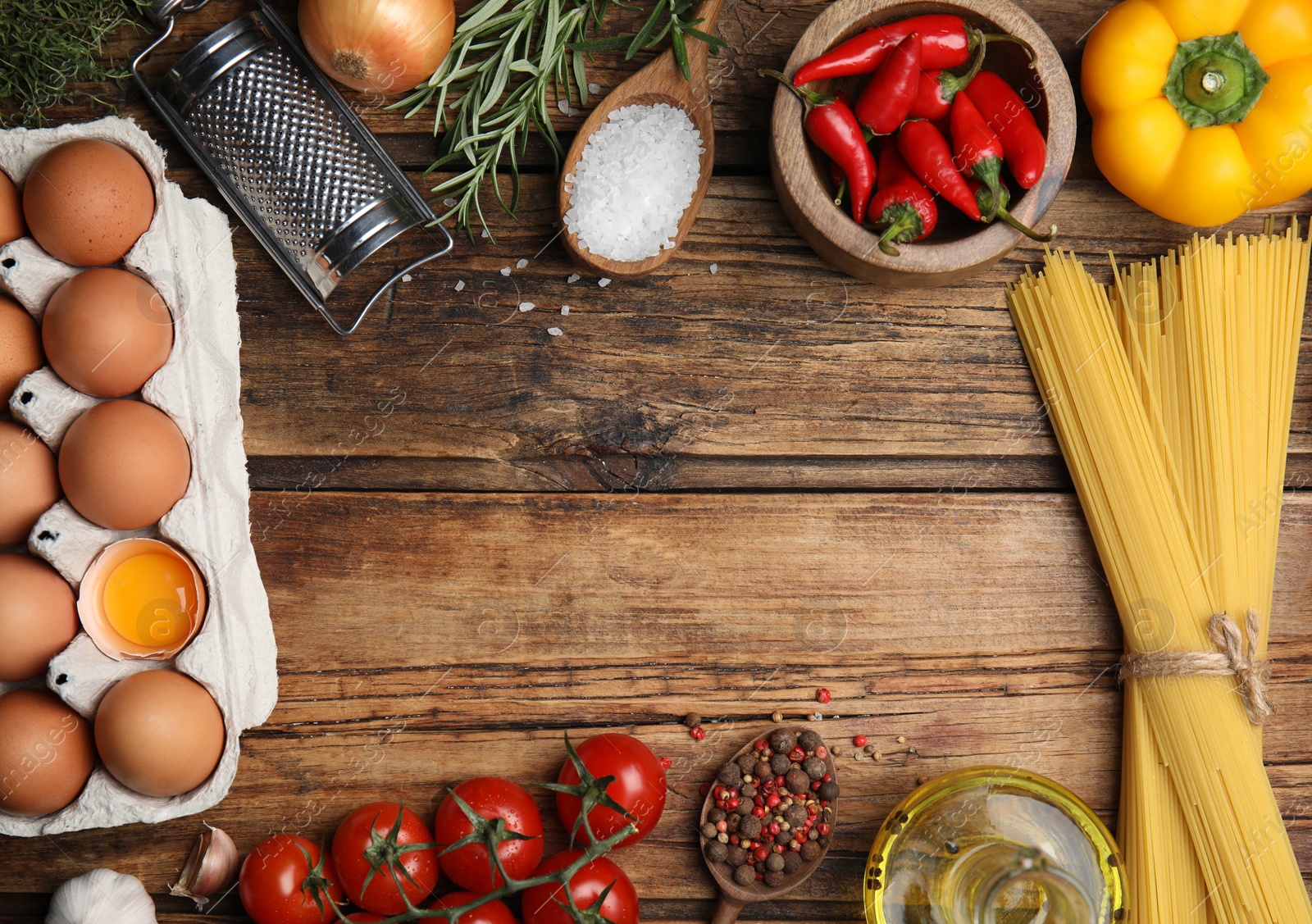 Photo of Frame made of cooking utensils and fresh food on wooden table, flat lay. Space for text