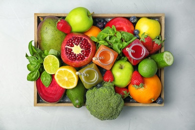 Photo of Crate with healthy detox smoothies and ingredients on light background, top view