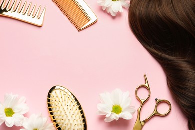 Flat lay composition with different hairdresser tools and flowers on pink background, space for text