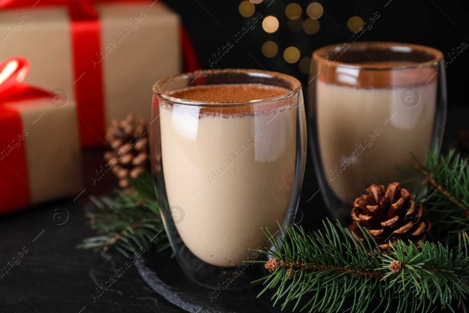 Photo of Delicious Christmas cocktail with liqueur on black table