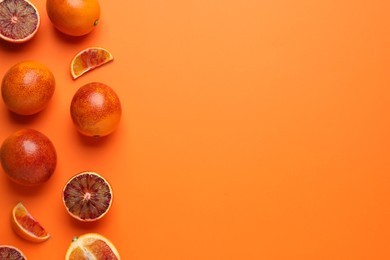 Photo of Many ripe sicilian oranges on orange background, flat lay. Space for text