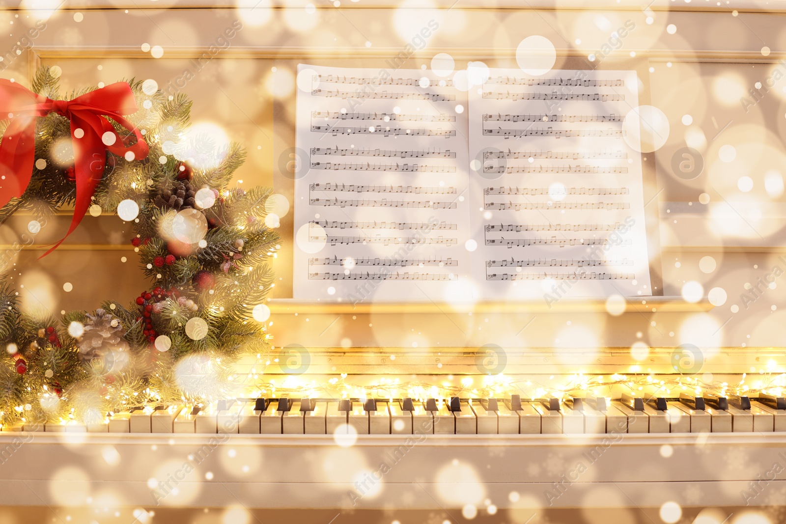 Image of Christmas and New Year music. Piano with festive wreath, bokeh effect