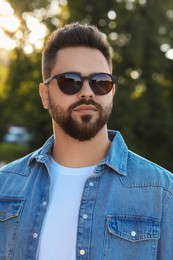 Handsome man in sunglasses outdoors on summer day