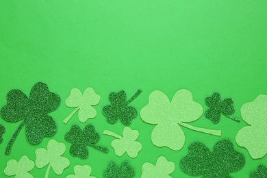 Photo of Decorative clover leaves on green background, flat lay with space for text. Saint Patrick's Day celebration