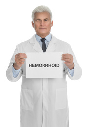 Photo of Doctor holding sign with word HEMORRHOID on white background