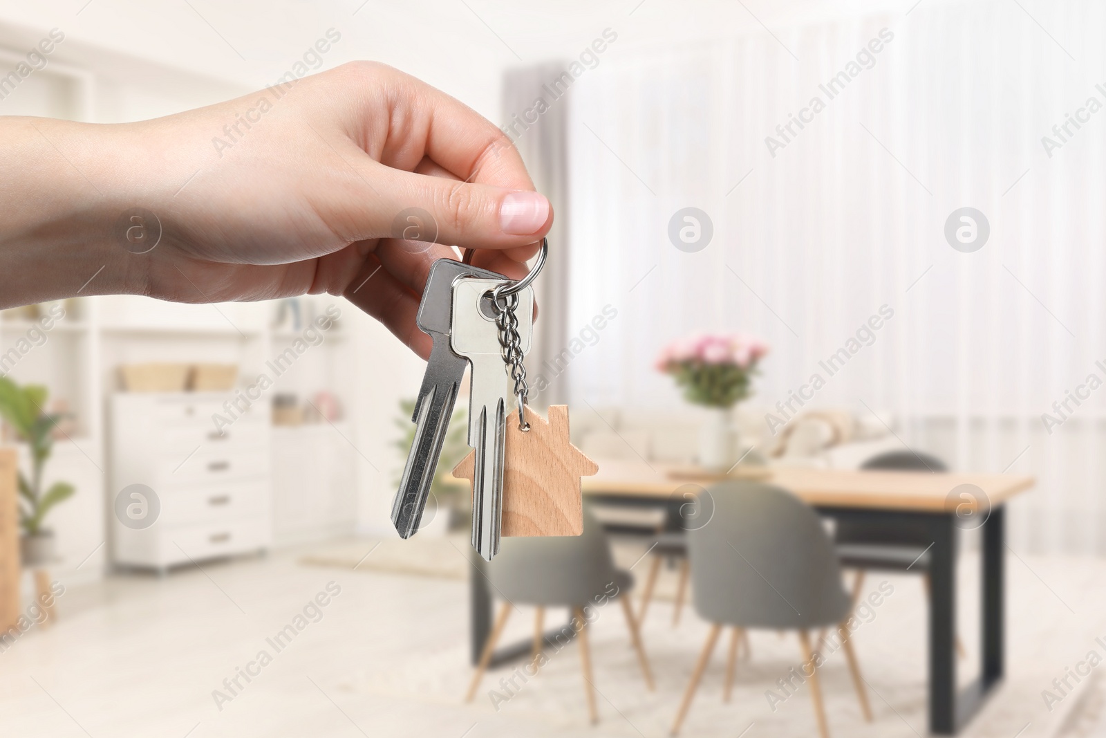Image of Woman holding house keys in room, closeup