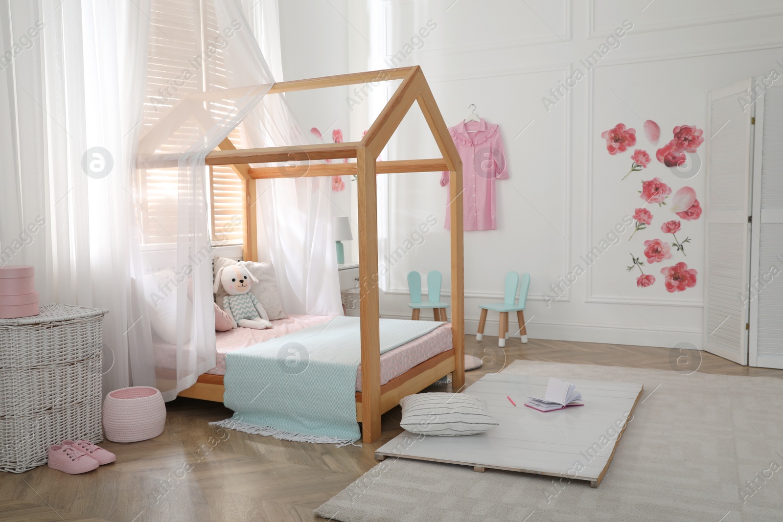 Photo of Stylish child room interior with wooden house bed