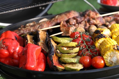 Photo of Tasty meat and vegetables on barbecue grill outdoors, closeup